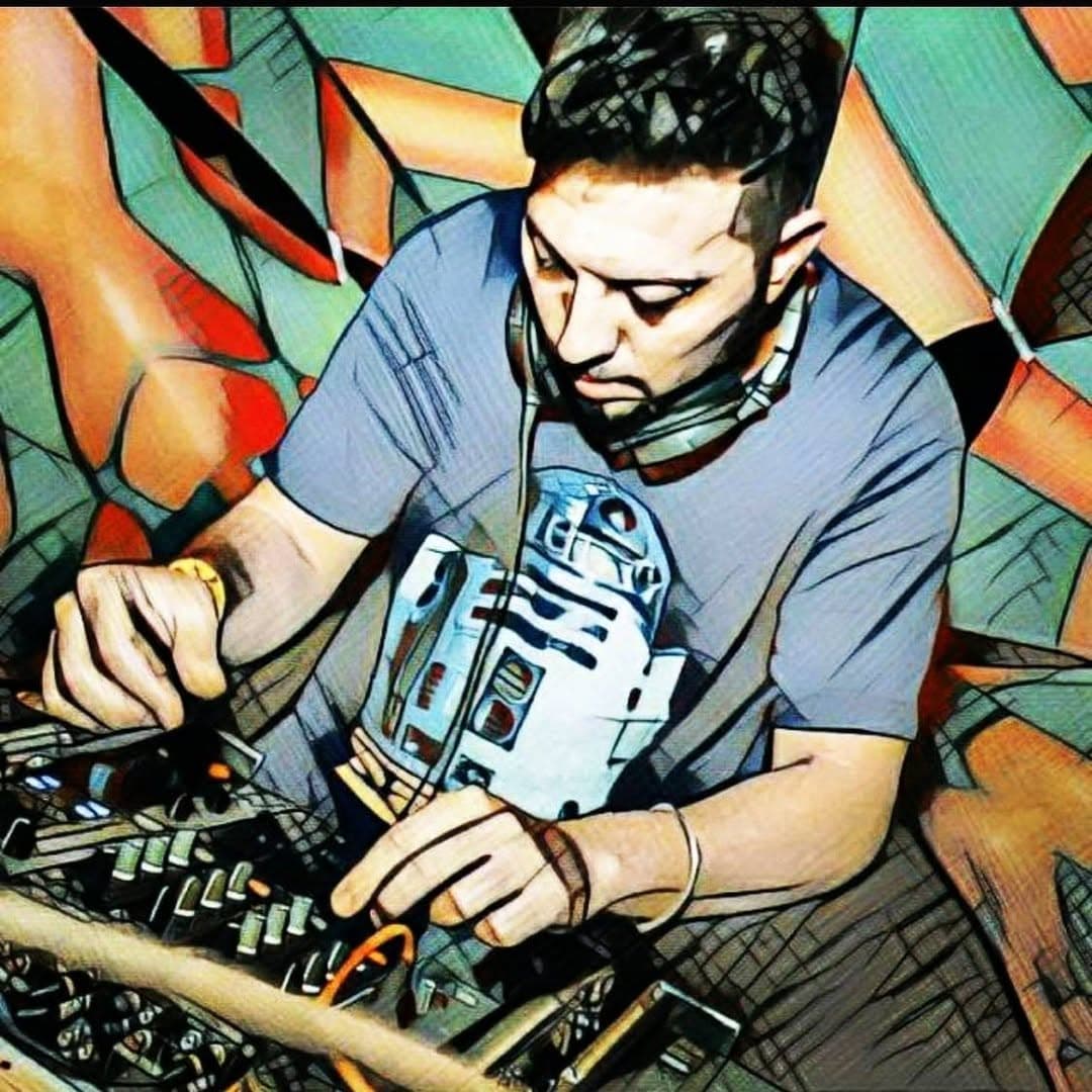 Darkelf playing the mixer, headphones around his neck